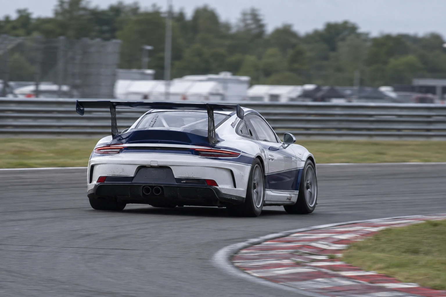 Illustration of a white and blue racing car cornering on a circuit